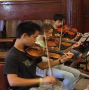 Young string players rehearsing on violin